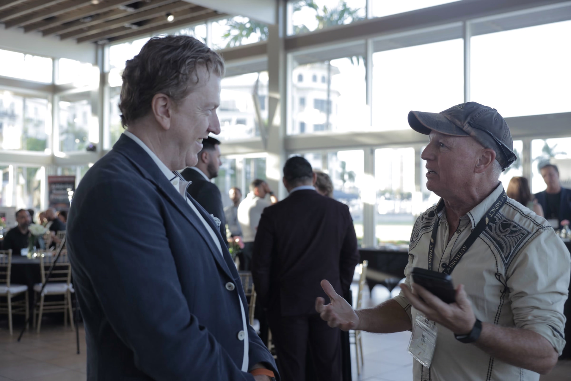 Two guests in conversation at the waterfront pavilion